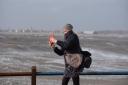 A woman battles gusts from Storm Eunice on Felixstowe seafront
