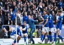 Ipswich Town players - and a jubilant fan - celebrate Bersant Celina's late winner against Fleetwood Town