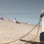 Visitors enjoying a sunny day at Dunwich beach on the Suffolk coast
