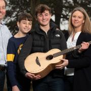 Graham, Henry, Jacob and Kellie Myers with their new guitar from Ed Sheeran.  Picture: Sarah Lucy Brown