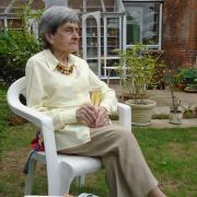 Annick Smith sipping champagne in her beloved garden in Ipswich on her 86th birthday.