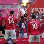 Morecambe's Samuel Lavelle (centre) and the team celebrate with the trophy after the Sky Bet League Two play-off final match held at Wembley back in May.